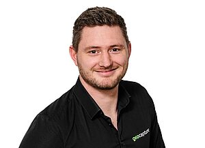 Porträt eines Mitarbeiters in schwarzem Hemd mit geoCapture-Logo vor weißem Hintergrund