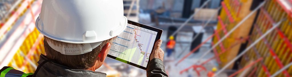 Man on construction site with tablet - Digital construction diary