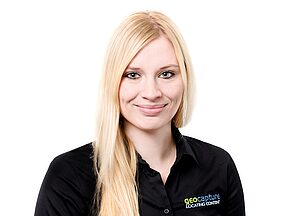 Frau mit langem blondem Haar trägt ein schwarzes Hemd mit geoCapture-Logo und lächelt in die Kamera vor weißem Hintergrund
