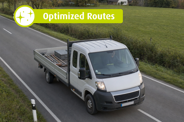 White flatbed truck driving on a rural road. Text in the image: “Optimized Routes”.